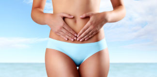 Jak rozpoznać infekcję intymną? Kobieta z rękami na brzuchu