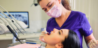 Braki w uzębieniu – jak je uzupełnić? Kobieta u dentysty