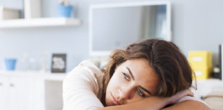 Gdy miesiączka krzyżuje Twoje plany… Kobieta leży na kanapie