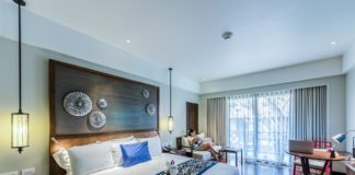 Nowe mieszkanie – stan deweloperski czy wykończenie pod klucz? Kobieta w dobrze urządzonej sypialni