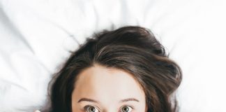 Jak spać, by się wyspać? Kobieta zakrywa się kołdrą