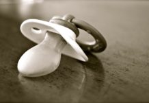 5 benefitów podawania smoczka dzieciom Smoczek na drewnianym blacie