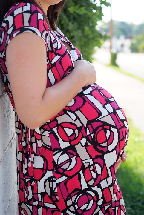 Kobieta w kolorowej sukience w ciąży