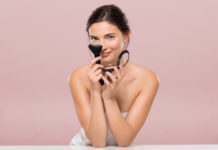 Promienna cera przez cały rok. Poznaj triki makijażystów! Kobieta z pędzlem do makijażu