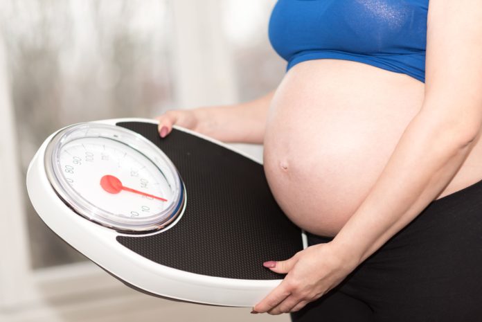 Kobieta w ciąży sprawdza wagę