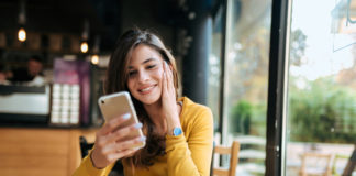 Najładniejsze smartfony dla kobiet Kobieta w restauracji patrzy w telefon