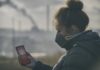 Smog – wielkie wyzwanie współczesności Kobieta w masce antysmogowej sprawdza zanieczyszczenie powietrza