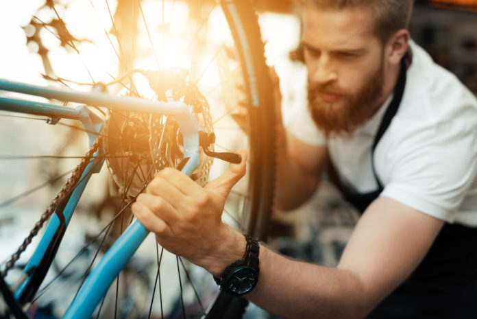 mężczyzna naprawiający rower