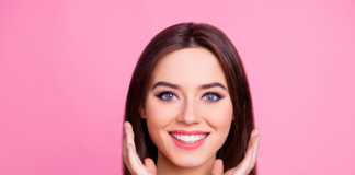 Codzienna pielęgnacja cery trądzikowej Piękna uśmiechnięta dziewczyna na różowym tle