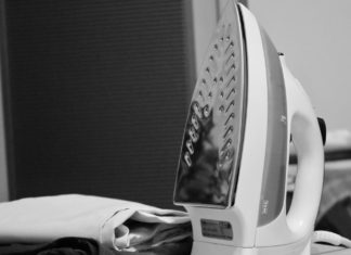 Manekin do prasowania oraz suszarka przemysłowa – co musisz o nich wiedzieć, kiedy otwierasz swoją pralnię? czarno białe zdjęcie żelazko obok uprasowanego ubrania