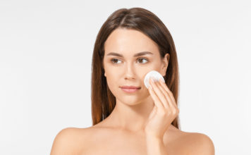 Płyn micelarny – skład oraz zastosowanie kobieta przecierająca twarz wacikiem kosmetycznym nasączonym płynem micelarnym