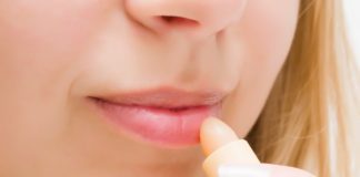 Spierzchnięte wargi – sprawdź sposoby na odbudowę ust! kobieta smarująca usta pomadką