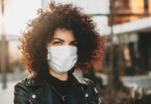 Co warto wiedzieć o maseczkach ochronnych? dziewczyna z kręconymi włosami w maseczce na twarzy