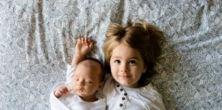Prywatne ubezpieczenie dziecka – dlaczego warto je mieć? dwoje małych dzieci na łóżku
