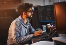 Popularne i dobrze płatne zawody w branży IT programista pracujący nocą przed komputerem