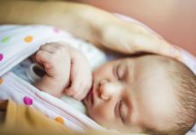 Rożek niemowlęcy – czym się różni od becika, jak go stosować? dziecko śpiące w rożku niemowlęcym