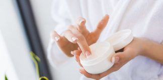 Kosmetyki naturalne – czy warto je stosować? kobieta nabierająca palcem krem do twarzy