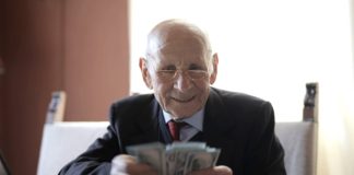 Wybór idealnego kredytu gotówkowego – jak korzystać z rankingów? starszy człowiek liczący pieniądze