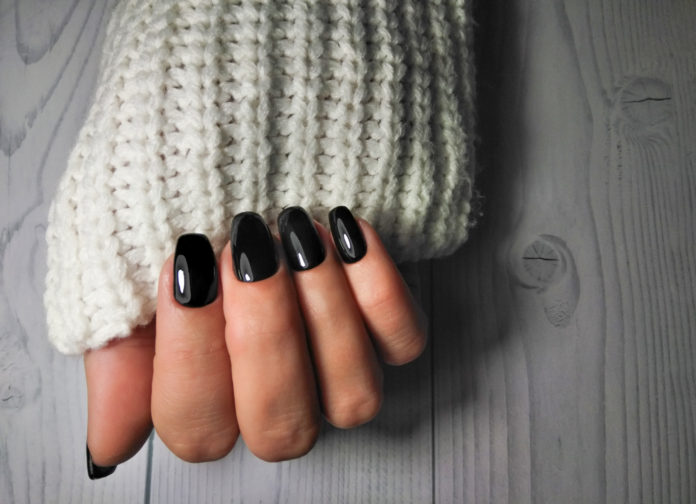dłoń z czarnym manicurem