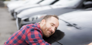 Najważniejsze formalności i kwestie po zakupie samochodu z drugiej ręki mężczyzna przytulający się do samochodu