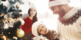 Pomysły na sprawdzone prezenty dla dzieci rodzina otwierająca prezenty pod choinką