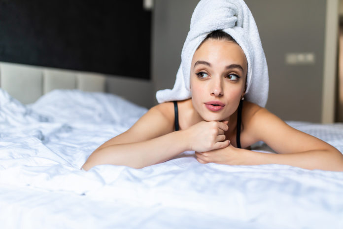 kobieta w ręczniku na głowie w sypialni