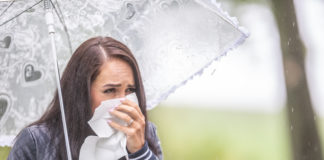 Jak walczyć z mokrym kaszlem? przeziębiona kobieta z parasolką