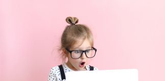 Ochrona rodzicielska – jak odpowiednio zabezpieczyć komputer? dziewczynka przed monitorem laptopa