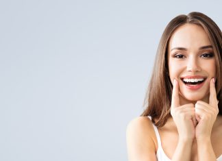 Chcesz zadbać o odporność? Zacznij od zębów! młoda kobieta podkreślająca uśmiech