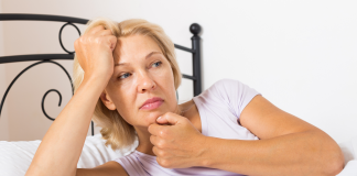 Dlaczego podczas menopauzy pojawiają się uderzenia gorąca? dojrzała kobieta w łóżku