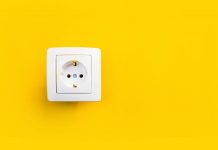 Gniazdka elektryczne w mieszkaniu – jak je poprawnie rozmieścić? gniazdko elektryczne na żółtym tle