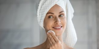 Olejek do demakijażu – jak używać go prawidłowo? Praktyczne porady kobieta demakijaż przed lustrem