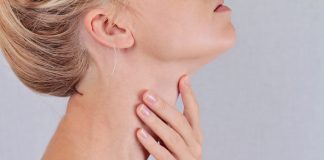 O czym może świadczyć niski poziom TSH? Tyreotropina - kobieta dotykająca szyi i sprawdzająca tarczycę