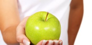 Psychodietetyka – czyli jak podejść do diety od strony psychologii? zielone jabłko na kobiecej dłoni
