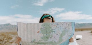 Wakacje w 2021 r. – w kraju lub za granicą? kobieta czytająca mapę samochodową