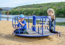 Dlaczego warto zainwestować w plac zabaw dla dziecka? dzieci na karuzeli