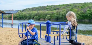 Dlaczego warto zainwestować w plac zabaw dla dziecka? dzieci na karuzeli