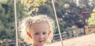 Huśtawka do pokoju dziecięcego — jak wybrać idealny model? dziewczynka na huśtawce