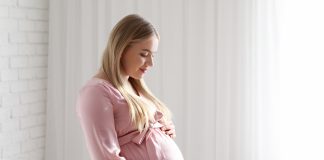 Garderoba przyszłej mamy – jakie ubrania przydadzą się w trzecim trymestrze? kobieta w ciązy w szlafroku