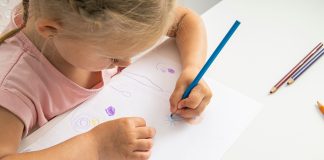 Meble rosnące z dzieckiem idealne do nauki – dlaczego warto i jak dokonać dobrego wyboru? dziewczynka przy biurku