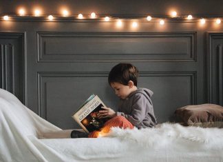 Łóżka jednoosobowe – jak wybrać model do pokoju dziecka? czytające dziecko